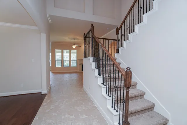 a view of staircase with railing and white walls