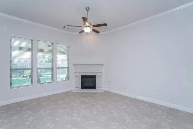 a view of an empty room with a fireplace and a window