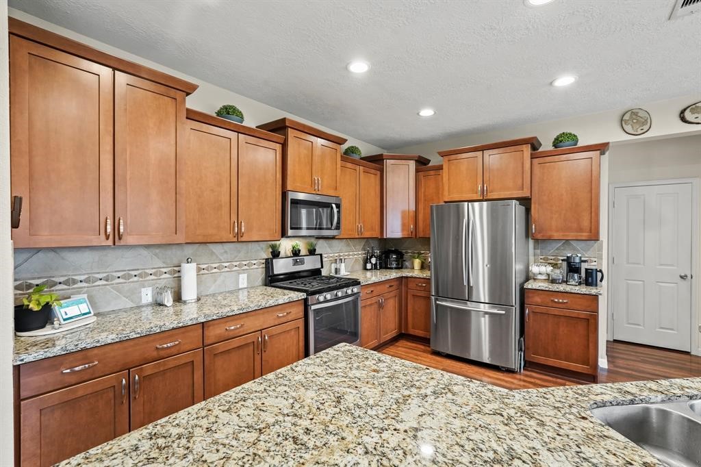 6719 Path Way Court Katy, TX 77449 - Photo 16 of 35 a kitchen with stainless steel appliances granite countertop a refrigerator a stove top oven and sink
