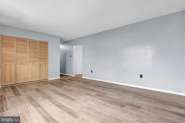 a view of an empty room with wooden floor
