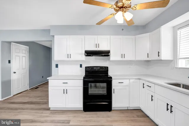a kitchen with white cabinets and appliances