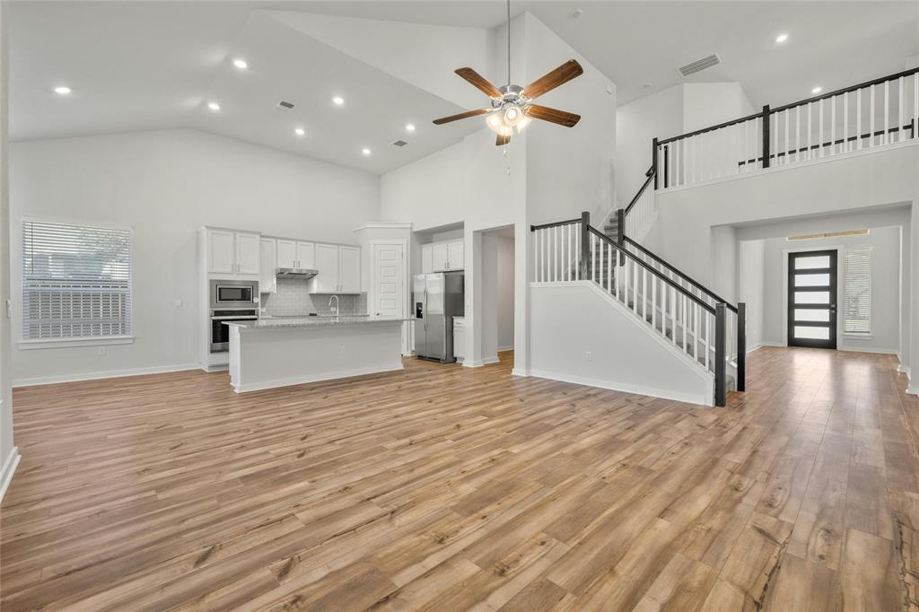 113 Shadow Oak Cove Georgetown, TX 78628 - Photo 4 of 40 Lofty ceilings and rich hardwood flooring complement an inviting kitchen and elegant staircase.