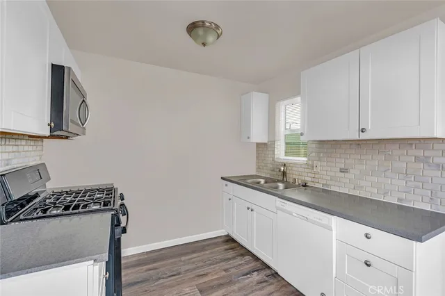 a kitchen with sink and white cabinets