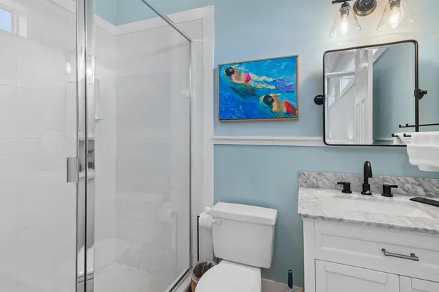 a bathroom with a granite countertop toilet a sink and mirror