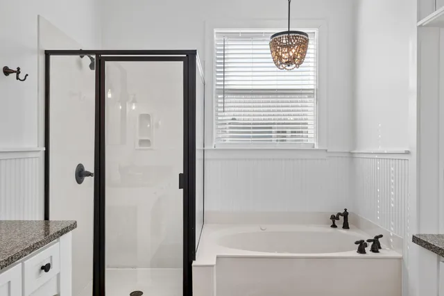 a bathroom with a granite countertop sink a mirror and shower