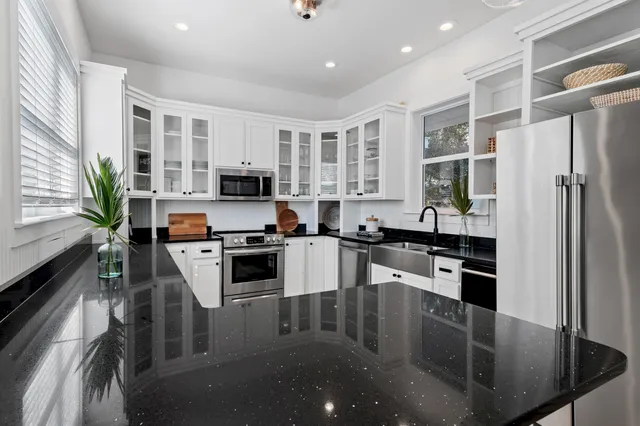 a kitchen with stainless steel appliances granite countertop a refrigerator a stove top oven a sink and dishwasher