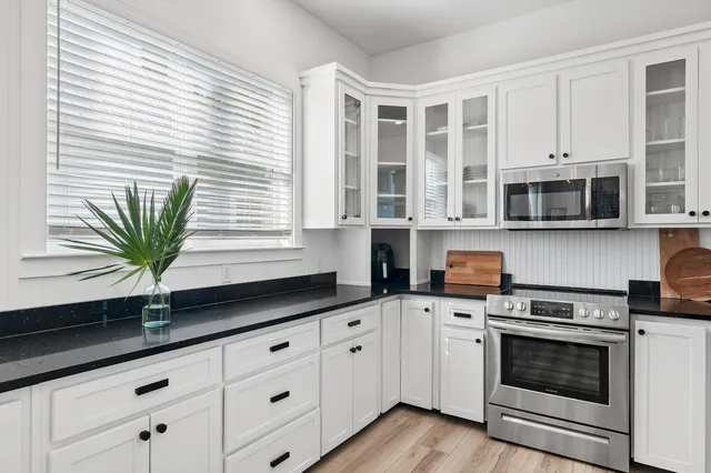 a kitchen with stainless steel appliances white cabinets and a granite counter tops