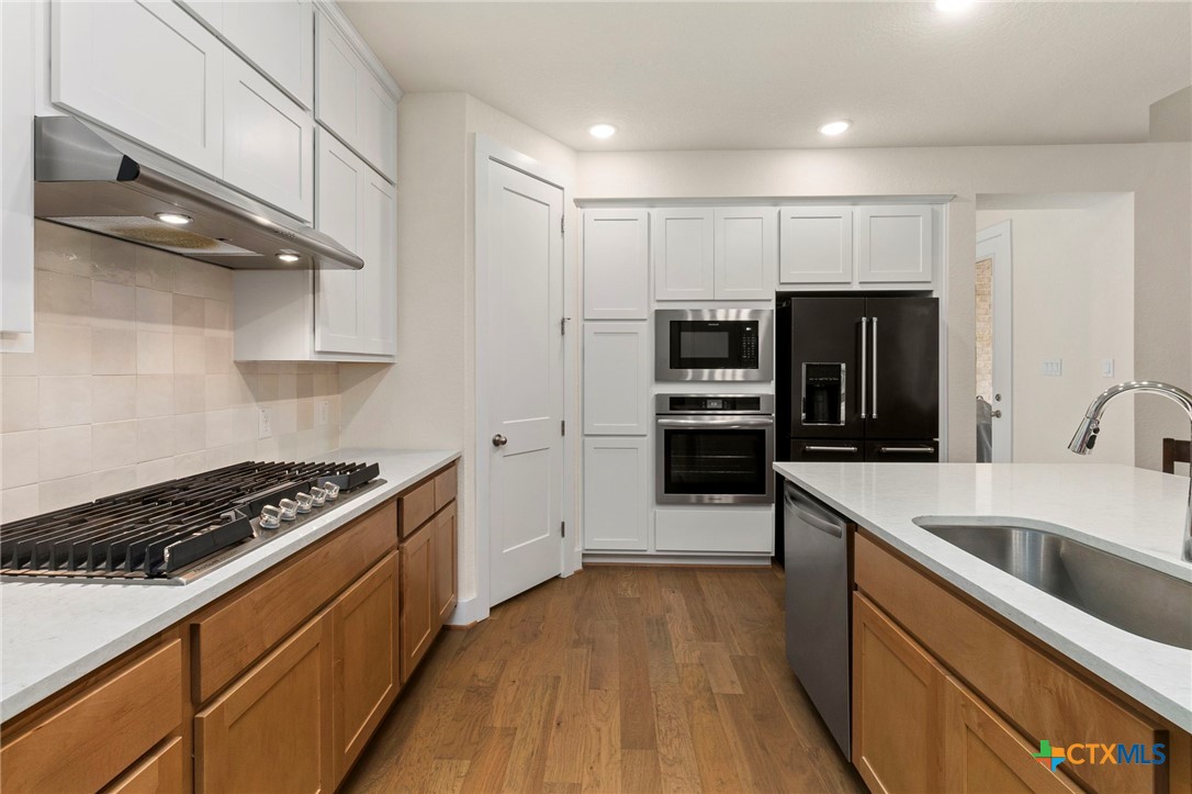 1845 Nettletree Road New Braunfels, TX 78132 - Photo 13 of 33 a kitchen with kitchen island stainless steel appliances a sink stove and refrigerator