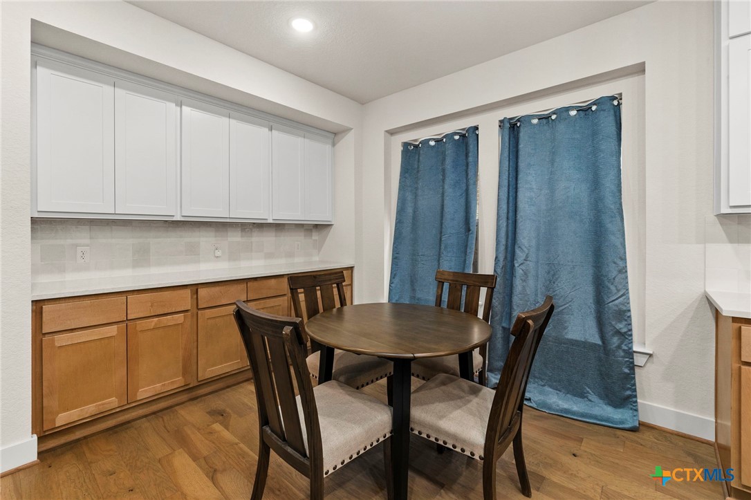 1845 Nettletree Road New Braunfels, TX 78132 - Photo 16 of 33 a kitchen with stainless steel appliances granite countertop a table chairs and a refrigerator