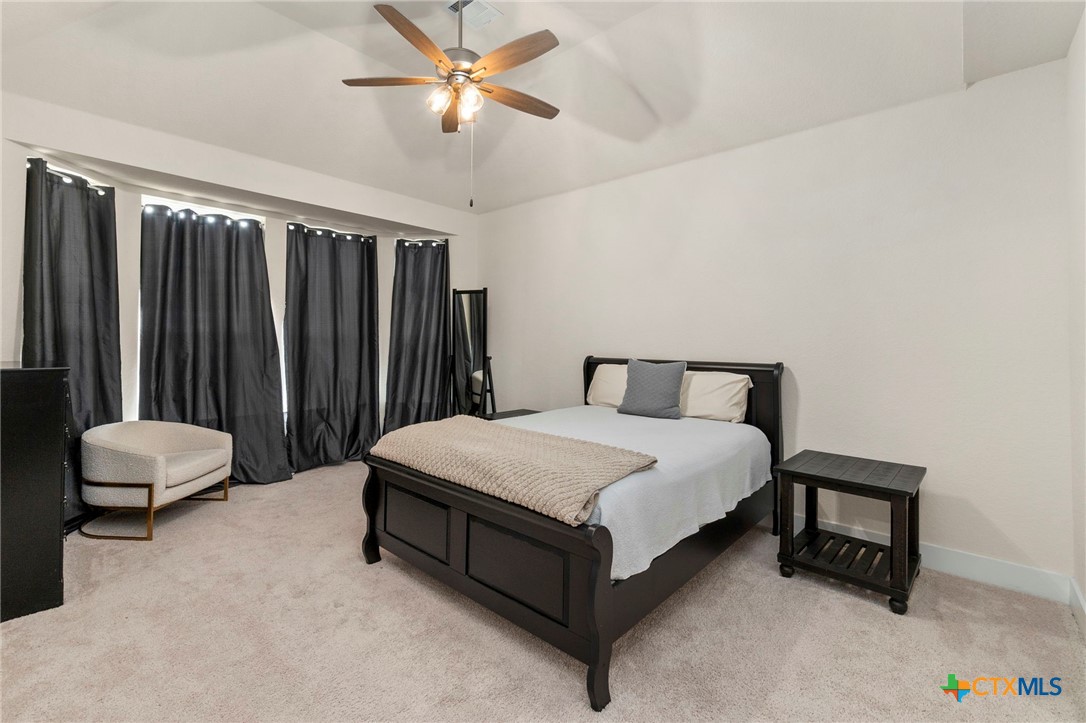 1845 Nettletree Road New Braunfels, TX 78132 - Photo 17 of 33 a spacious bedroom with a bed and a ceiling fan