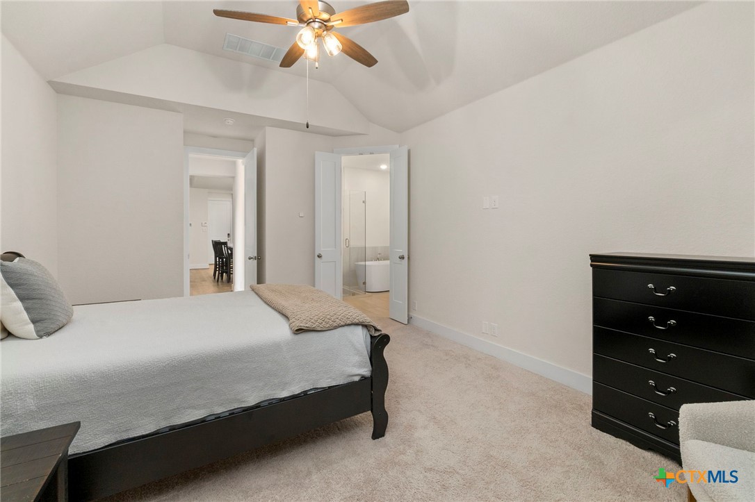 1845 Nettletree Road New Braunfels, TX 78132 - Photo 18 of 33 a bedroom with a bed and a chandelier