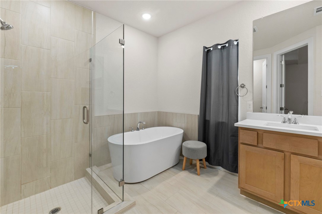 1845 Nettletree Road New Braunfels, TX 78132 - Photo 19 of 33 a spacious bathroom with a tub sink and mirror