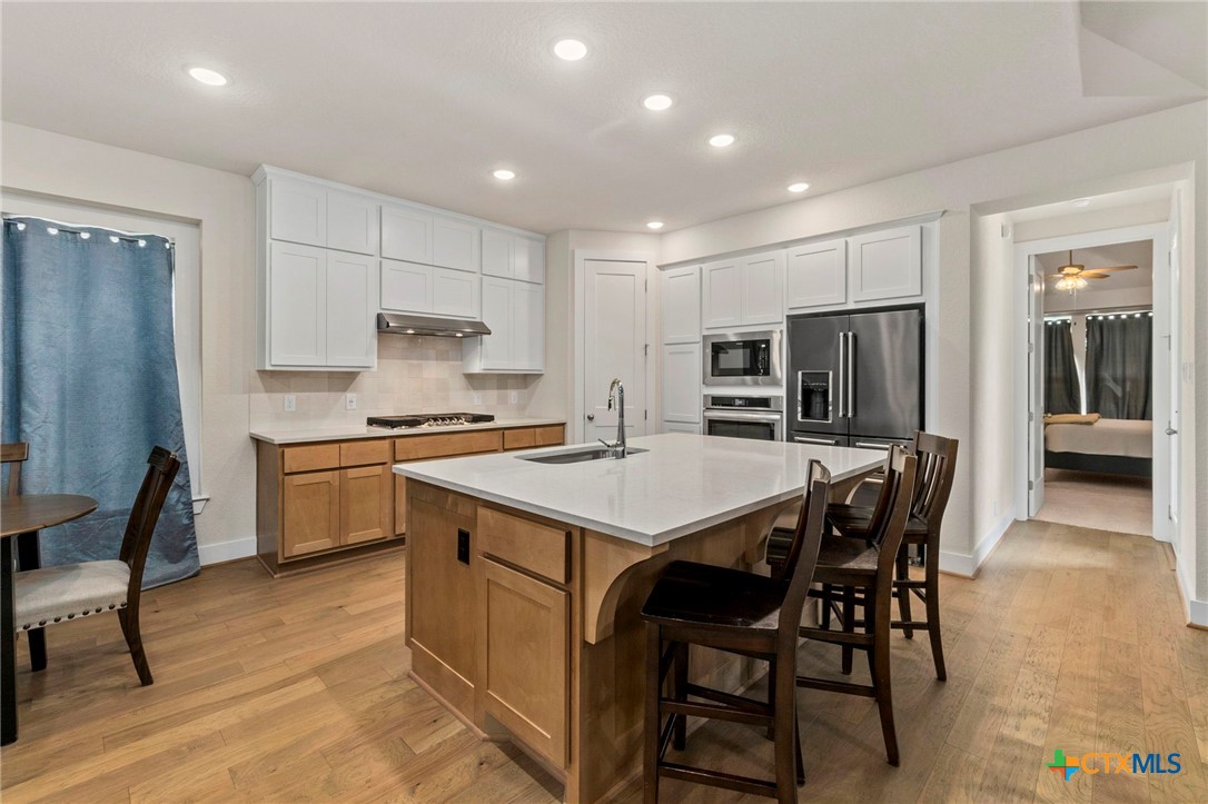 1845 Nettletree Road New Braunfels, TX 78132 - Photo 9 of 33 a kitchen with a table chairs refrigerator and microwave