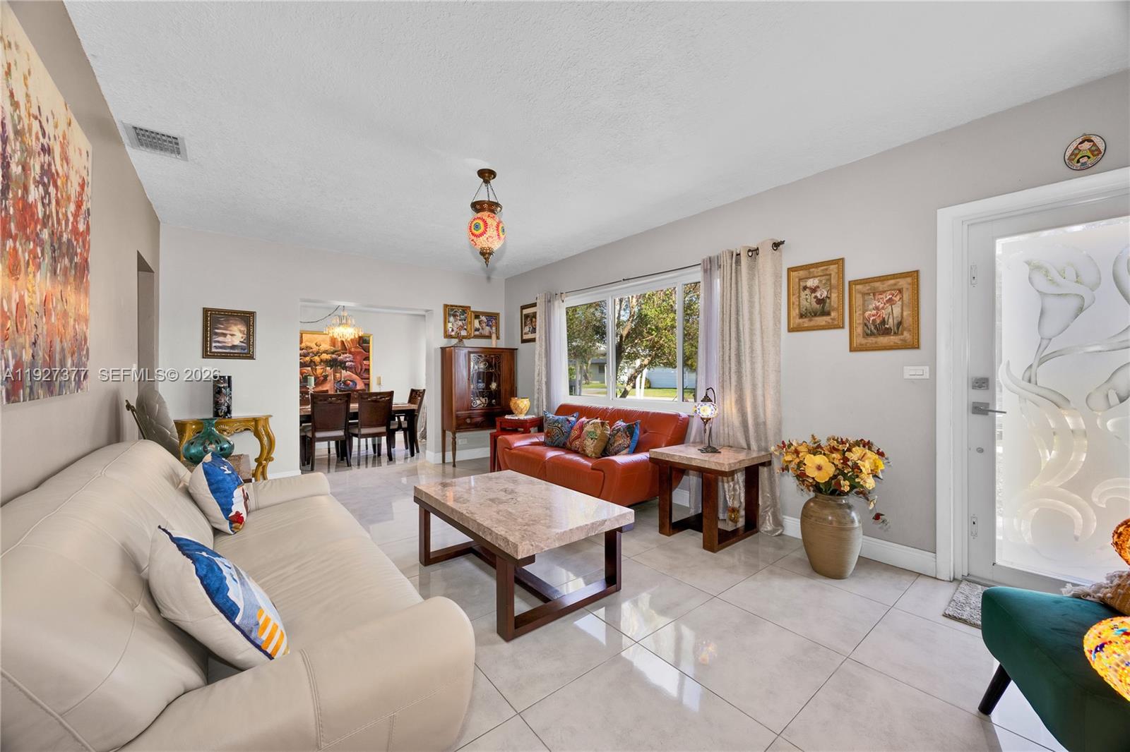4110 West 7th Lane Hialeah, FL 33012 - Photo 11 of 22 a living room with furniture and flowers