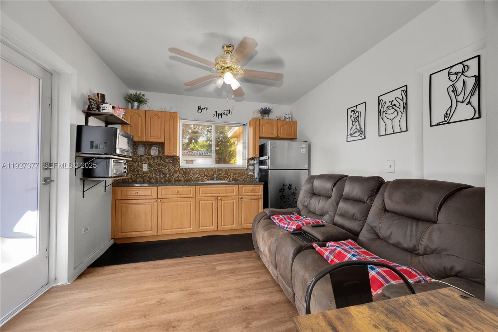 4110 West 7th Lane Hialeah, FL 33012 - Photo 14 of 24 a living room with furniture and kitchen view