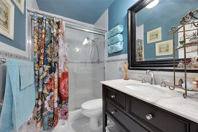 a bathroom with a granite countertop sink a toilet and a mirror