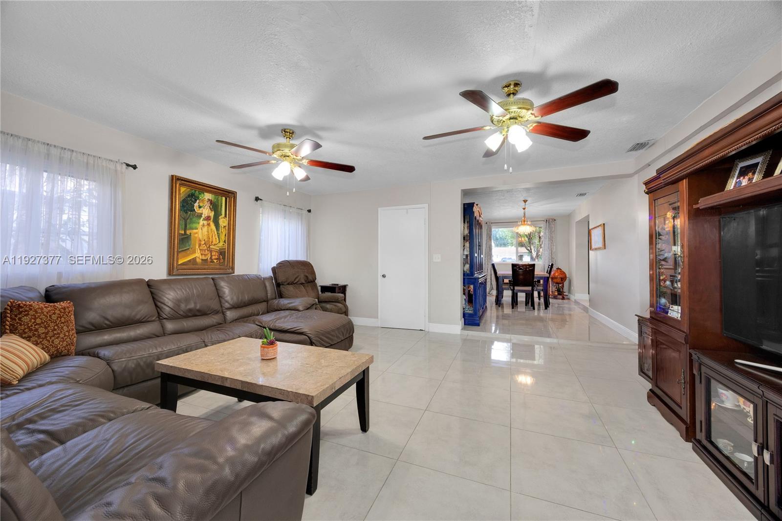 4110 West 7th Lane Hialeah, FL 33012 - Photo 9 of 22 a living room with furniture a fireplace and a flat screen tv