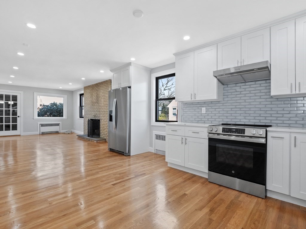 48 Albert Street Waltham, MA 02453 - Photo 11 of 37 a kitchen with stainless steel appliances granite countertop a stove and a refrigerator