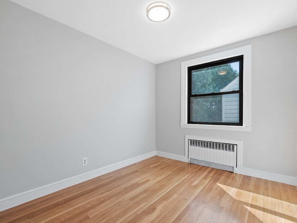 48 Albert Street Waltham, MA 02453 - Photo 15 of 37 a view of an empty room with wooden floor and a window