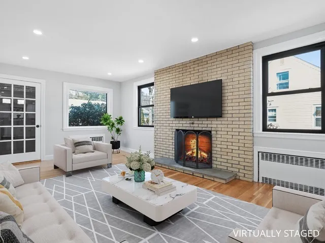 a living room with furniture a flat screen tv and a fireplace
