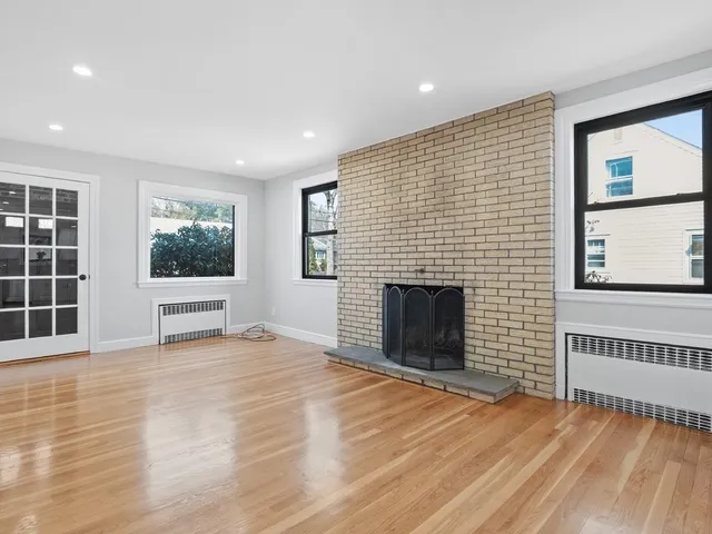 a view of an empty room with a window and fire place