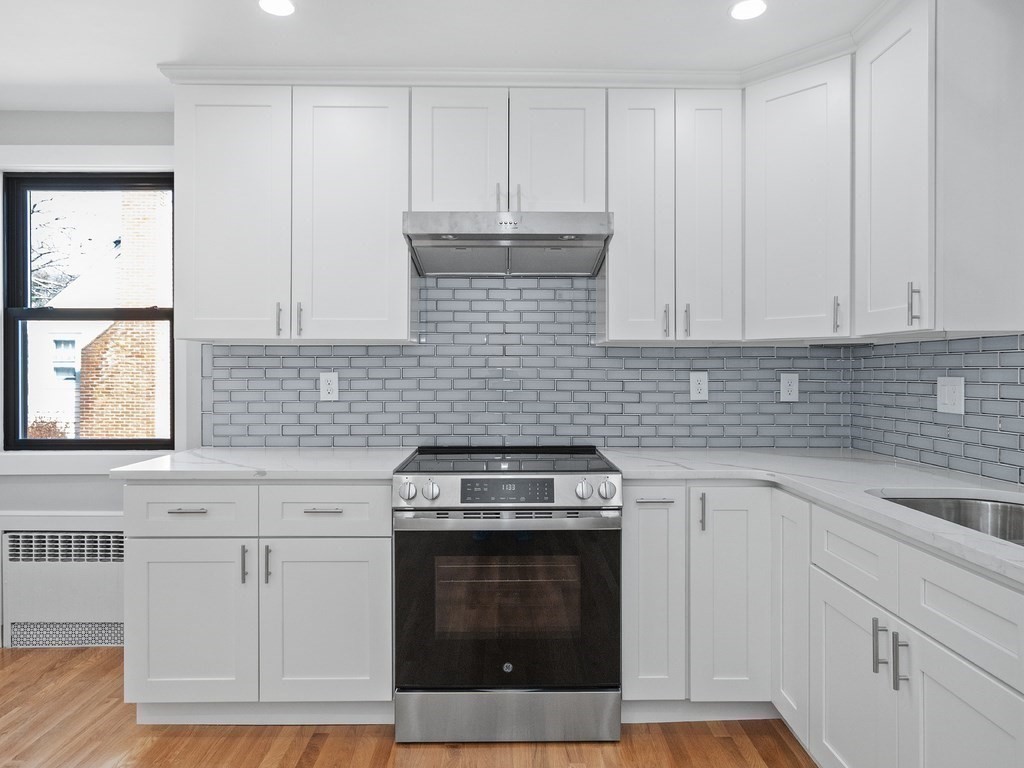 48 Albert Street Waltham, MA 02453 - Photo 10 of 37 a kitchen with granite countertop white cabinets and stainless steel appliances