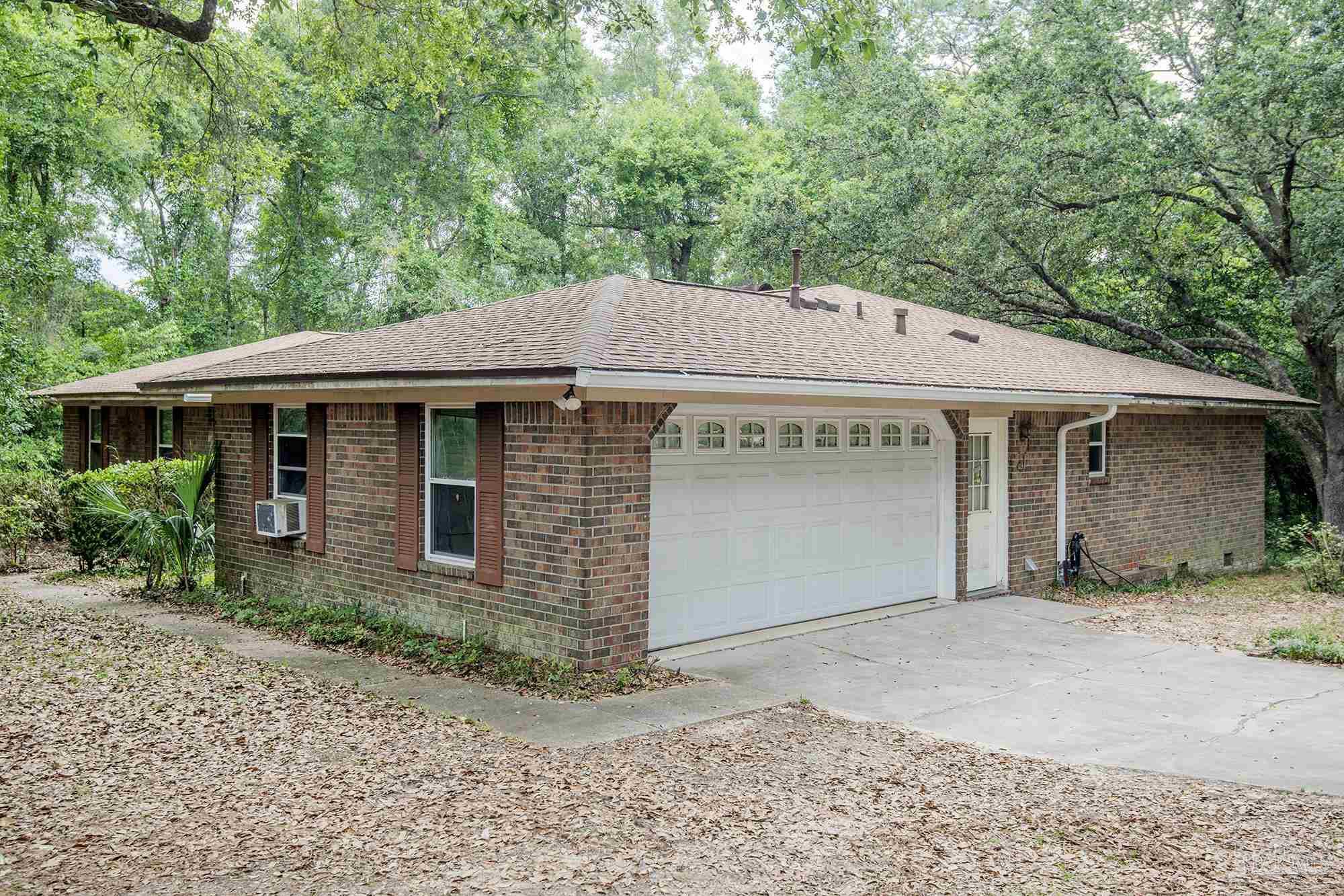 1210 Goldenrod Road Cantonment, FL 32533 - Photo 3 of 50 a front view of a house with a garden and yard
