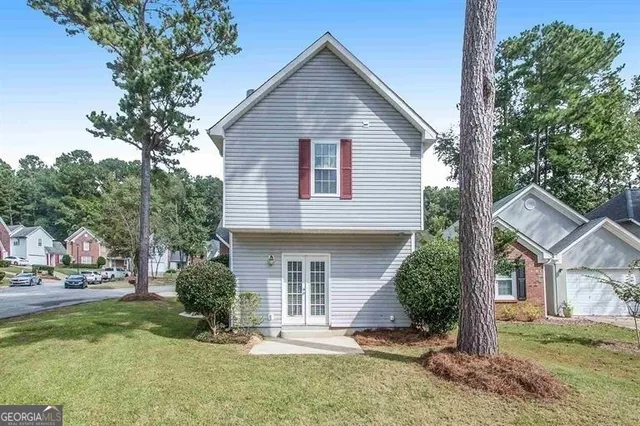 a view of a house with a yard and potted plants