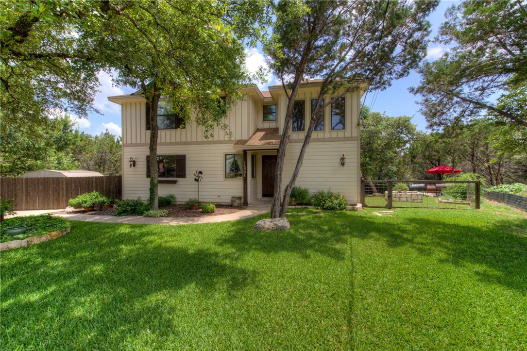 a view of backyard with house and a large tree