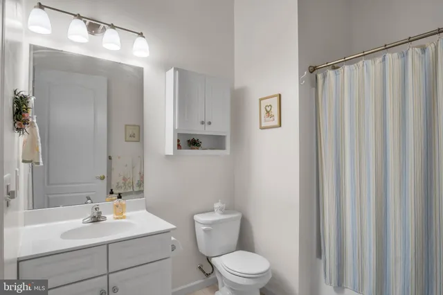 a bathroom with a sink vanity mirror and toilet