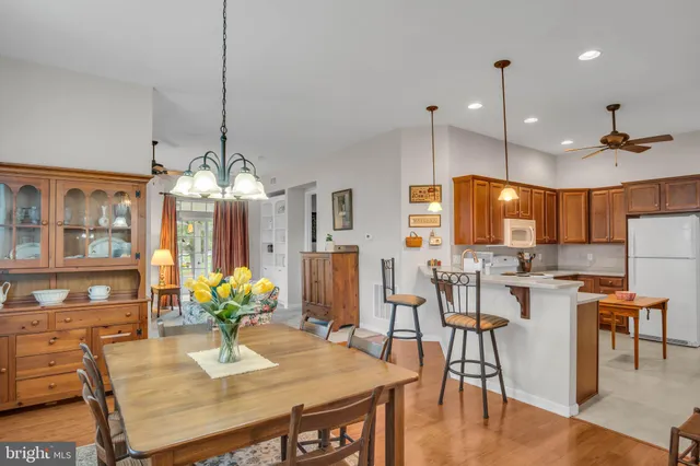 a view of a dining room and livingroom furniture wooden floor a chandelier a wooden table and chairs