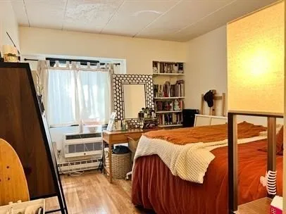 a bedroom with a bed and a flat tv screen on the dresser