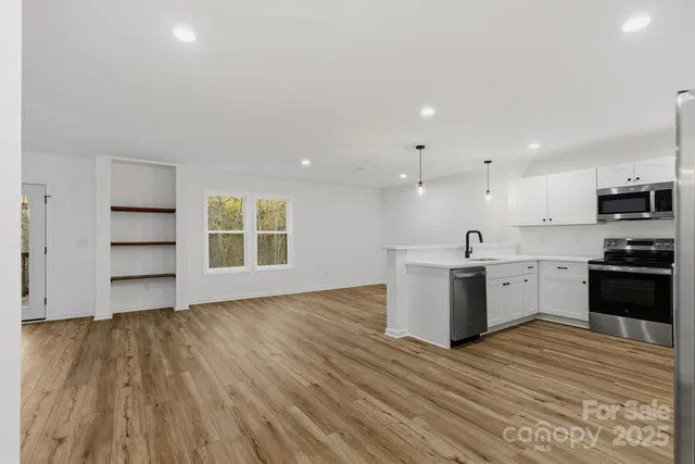 a view of kitchen with wooden floor and electronic appliances