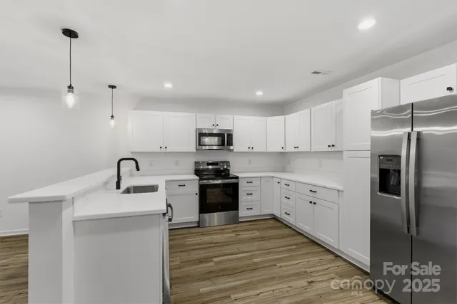 a kitchen with a refrigerator sink and white cabinets