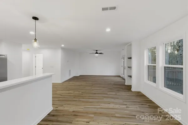 a view of empty room with wooden floor