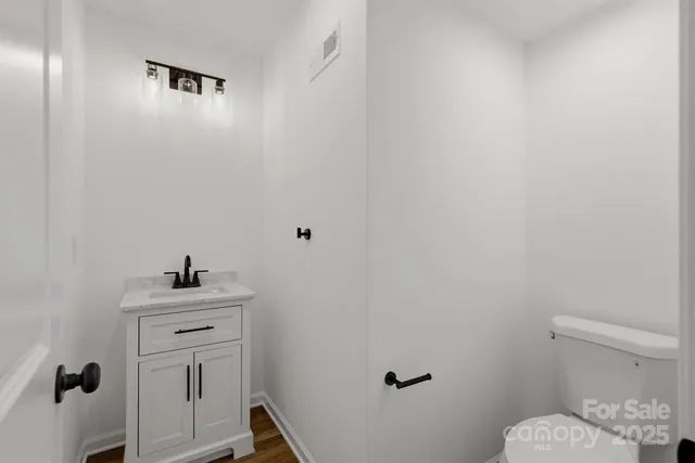 a bathroom with a sink mirror vanity and toilet