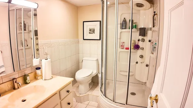 a bathroom with a sink a toilet and shower