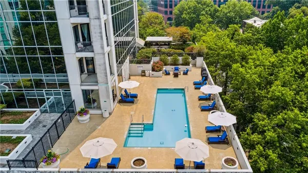 a view of a swimming pool with chairs and potted plants