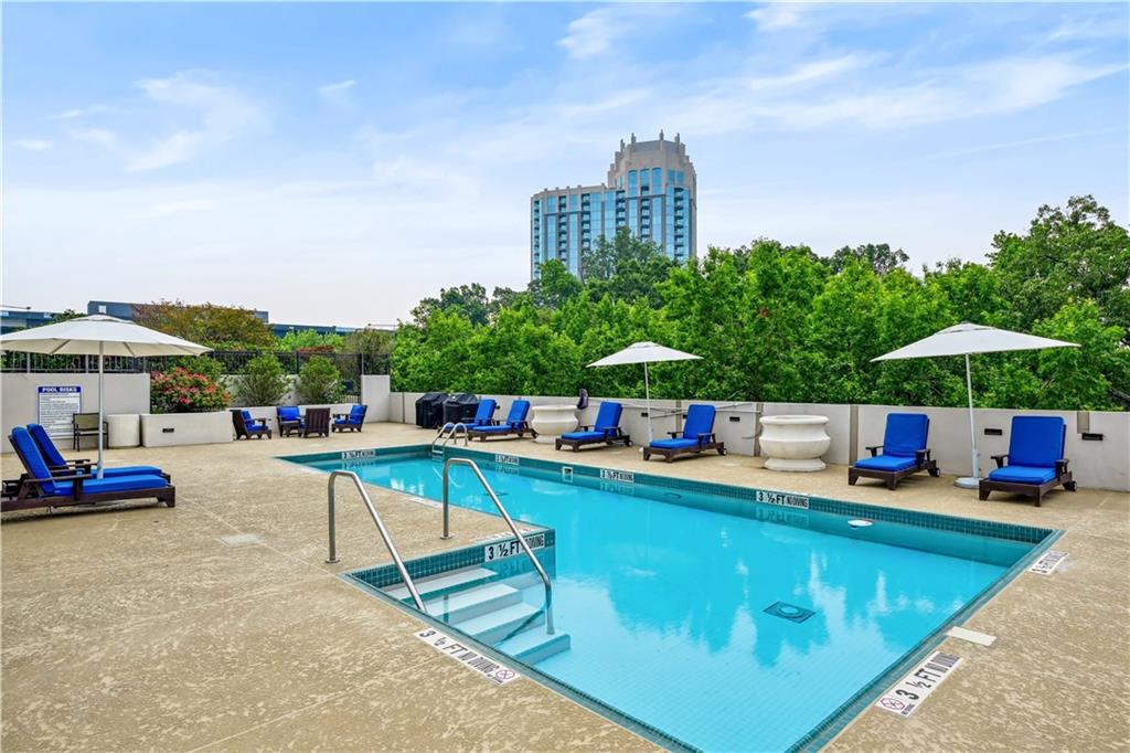 2828 Peachtree Road Northwest, Unit 2502 Atlanta, GA 30305 - Photo 28 of 38 a view of a swimming pool with lounge chairs in patio