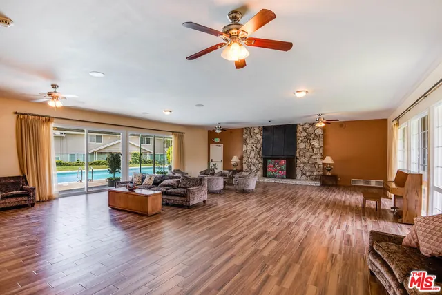 a living room with furniture fireplace and large windows
