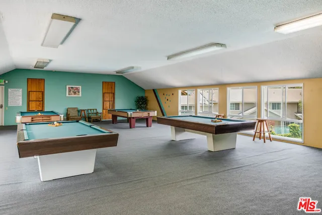 a living room with patio furniture and a potted plant