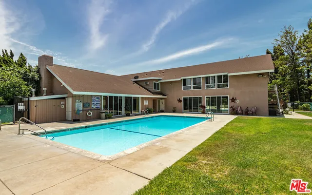 a front view of a house with yard and glass windows