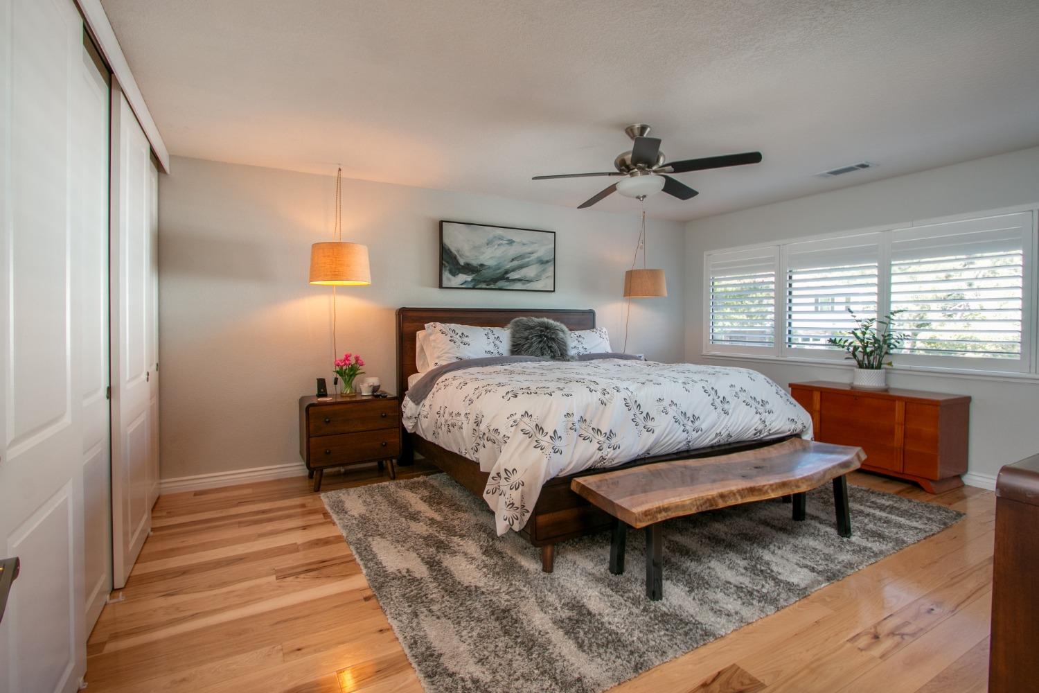 14975 Lago Drive Rancho Murieta, CA 95683 - Photo 12 of 41 a bedroom with a bed a dresser and a chandelier
