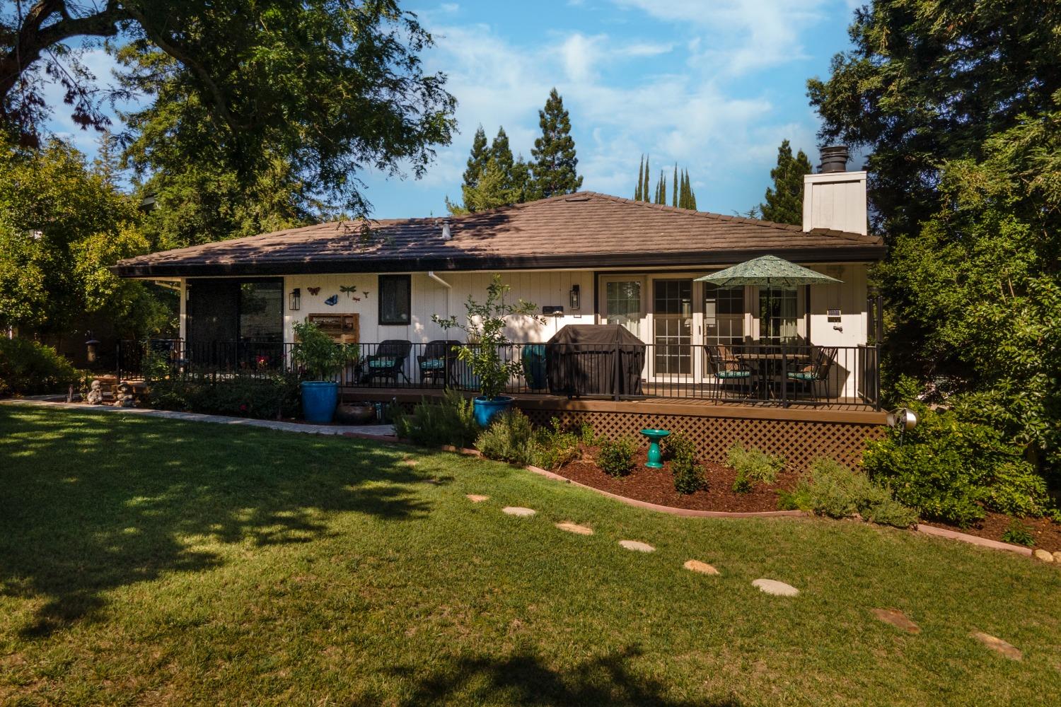 14975 Lago Drive Rancho Murieta, CA 95683 - Photo 38 of 41 a view of a patio with table and chairs under an umbrella
