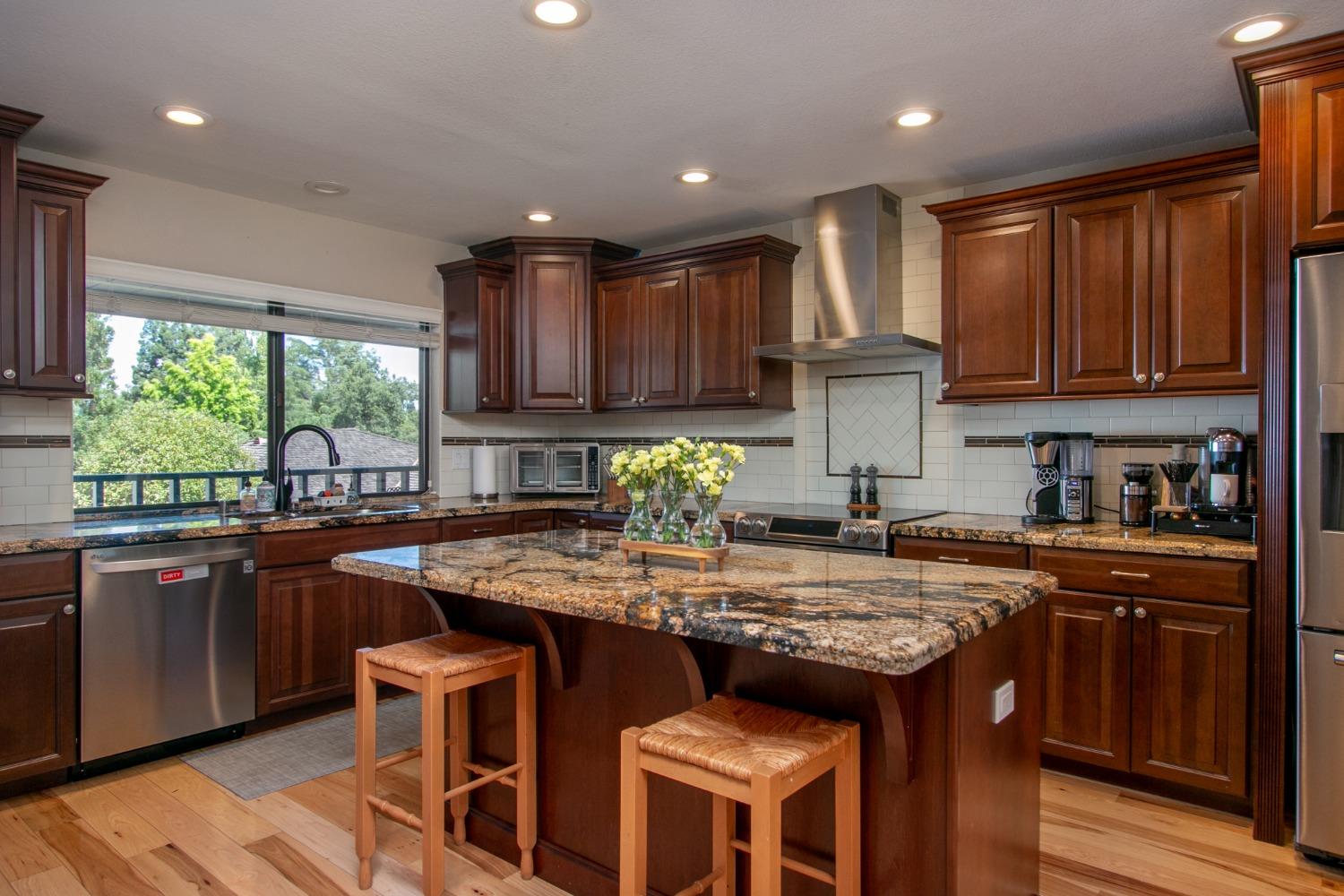 14975 Lago Drive Rancho Murieta, CA 95683 - Photo 5 of 41 a kitchen with kitchen island granite countertop wooden cabinets and a refrigerator