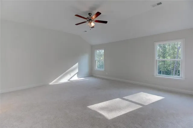 an empty room with ceiling fan and window