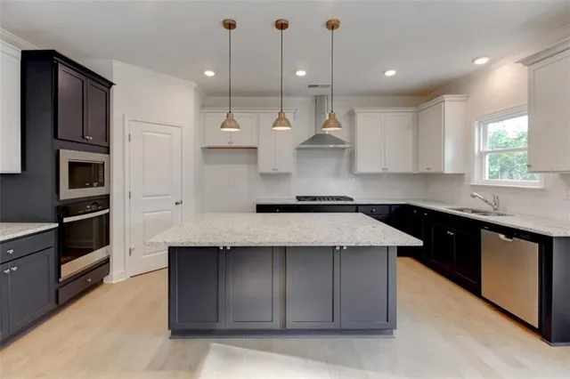a kitchen with kitchen island a sink stainless steel appliances and cabinets