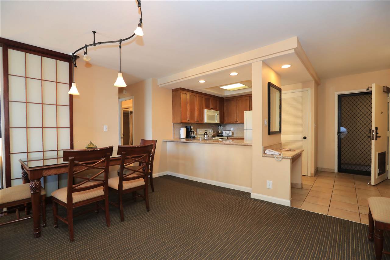 4401 Lower Honoapiilani Road, Unit B501 Lahaina, HI 96761 - Photo 6 of 14 a kitchen with a table chairs refrigerator and microwave