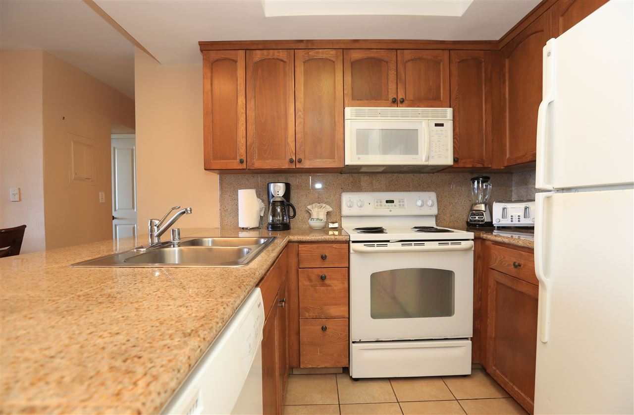 4401 Lower Honoapiilani Road, Unit B501 Lahaina, HI 96761 - Photo 10 of 14 a kitchen with a stove top oven sink and cabinets