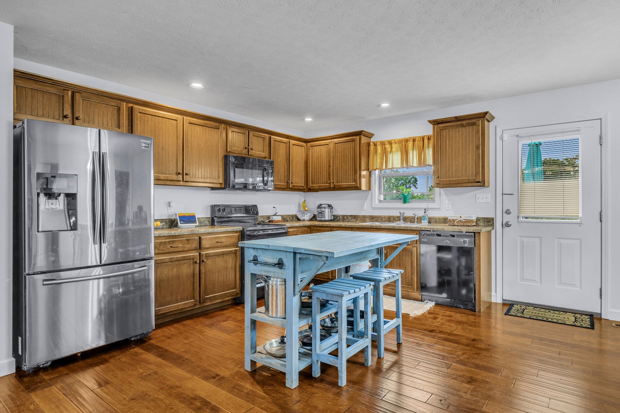 2164 Akersville Road Lafayette, TN 37083 - Photo 17 of 32 a kitchen with granite countertop wooden floors stainless steel appliances and a window